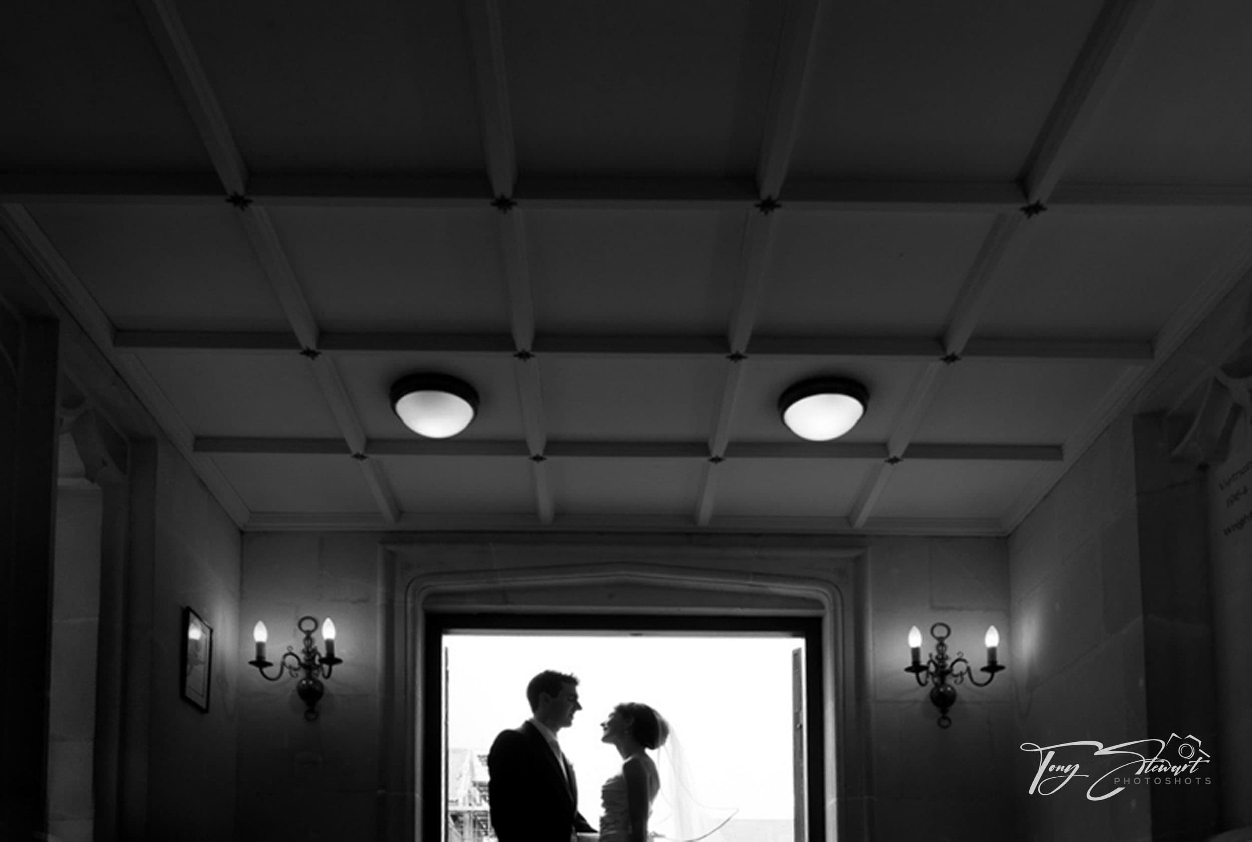 Couple silhoutetted in doorway on their wedding day.