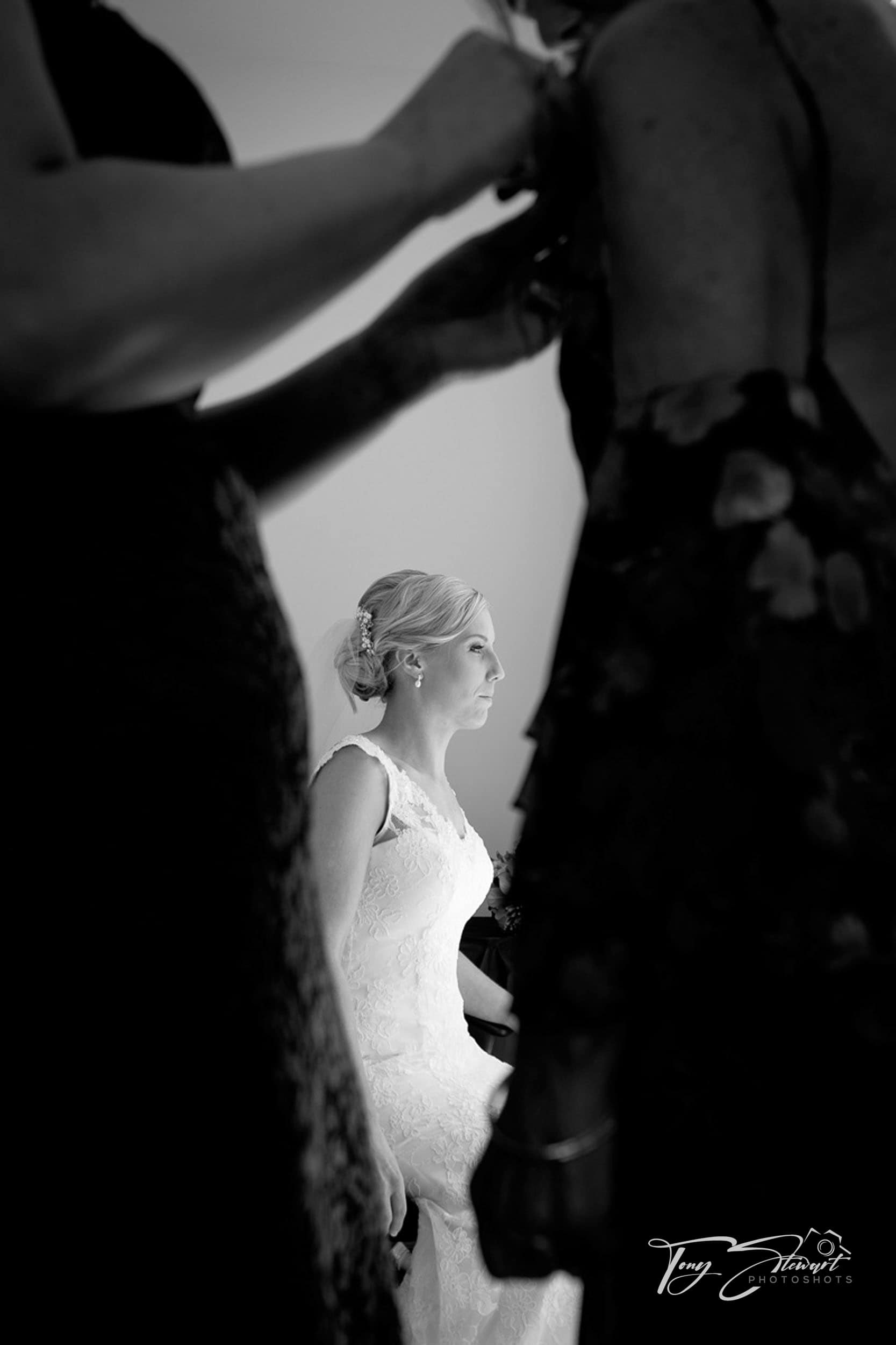 Anxious bride pauses while bridesmaids get finished.