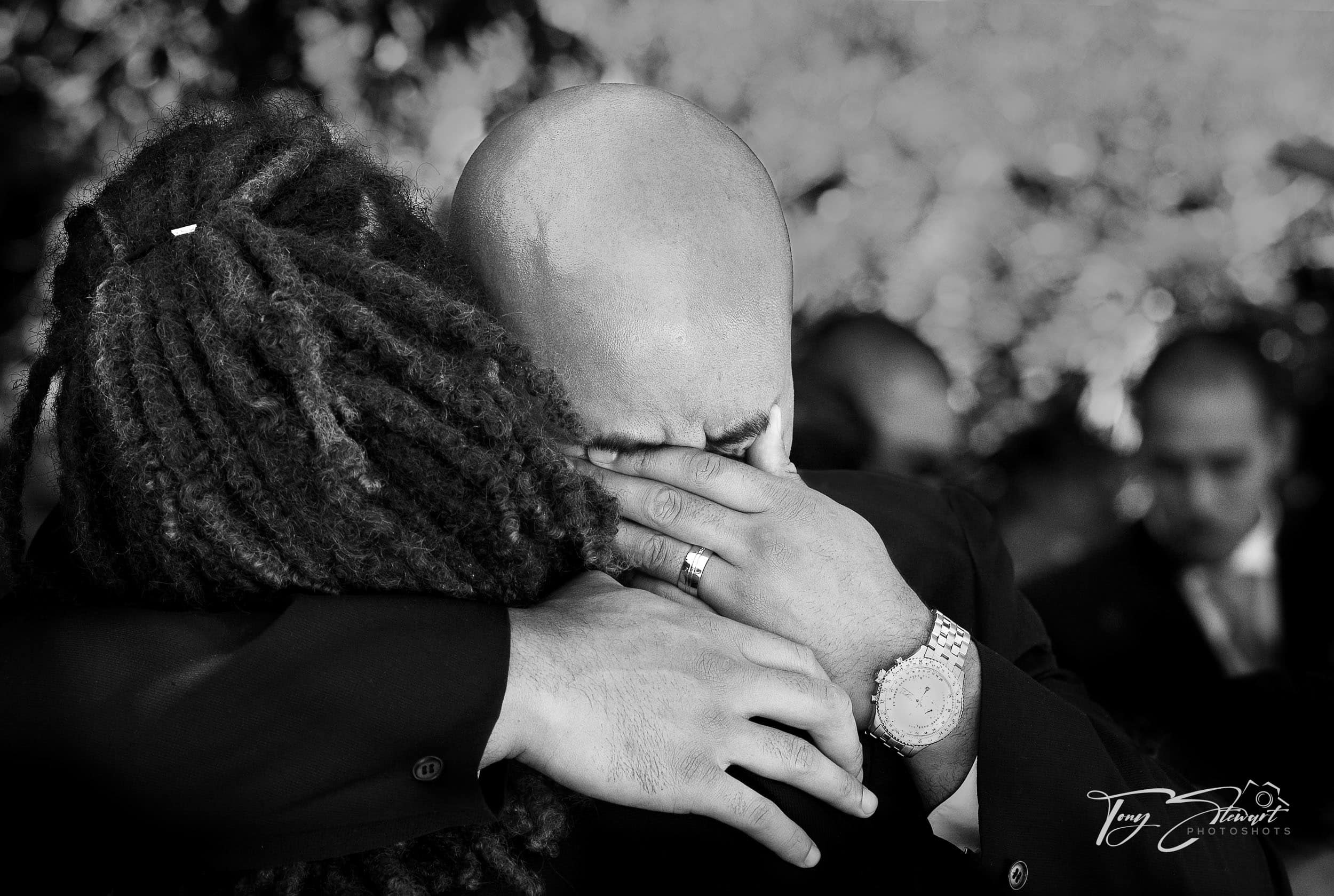 Groom cries and is comforted by best man during wedding.