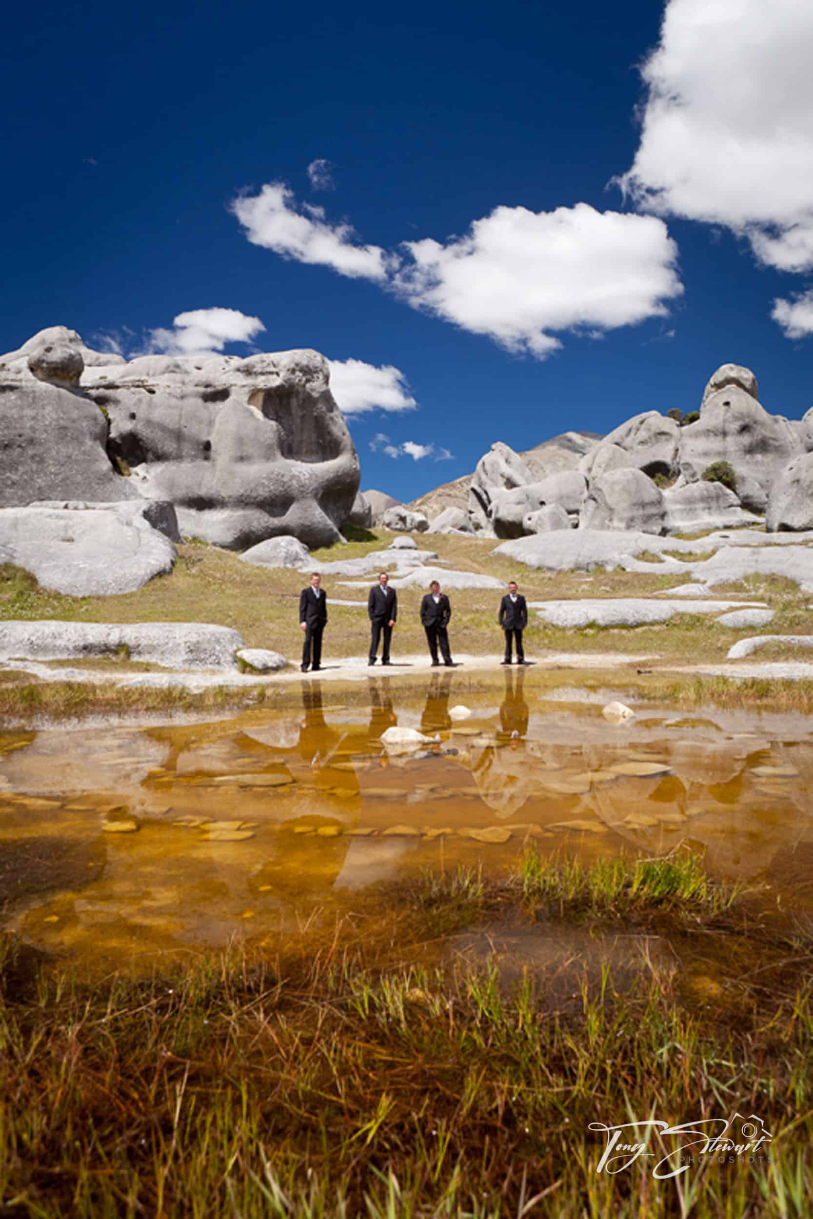 Four groomsmen reflected in pond, Castle Hill.